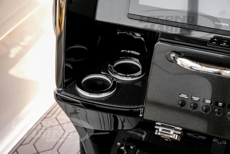 Slide: The Image of 2024 Nor-Tech 390 Sport Center Console dashboard with carbon fiber finish and cup holders. - 21