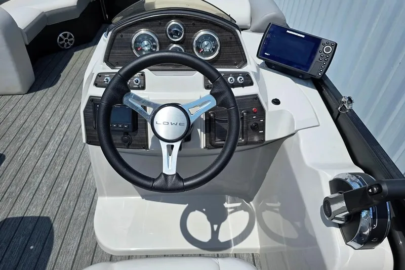 Slide: The Image of 2023 Lowe SS 210 boat dashboard with steering wheel and navigation system. - 10