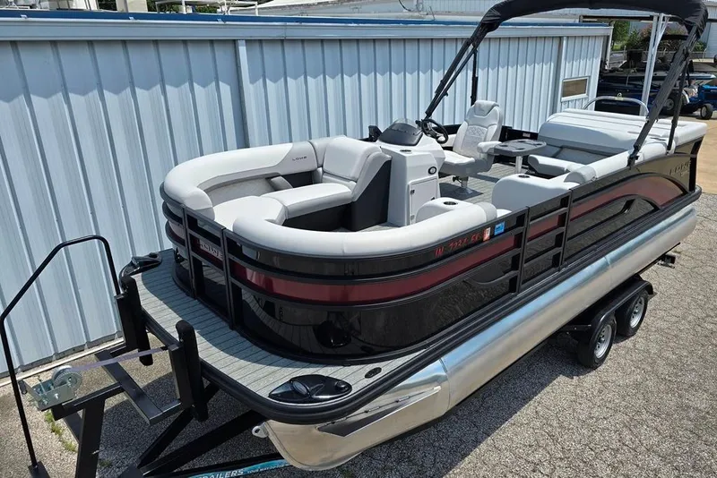 The Image of 2023 Lowe SS 210 pontoon boat on trailer, featuring sleek design and spacious seating. - 0
