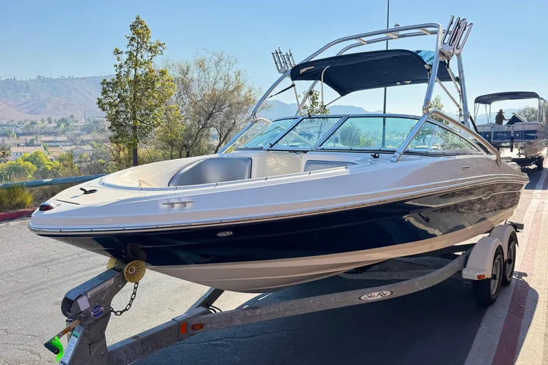 Slide: The Image of 2008 Sea Ray 205 Sport boat on trailer, parked outdoors with scenic background. - 3