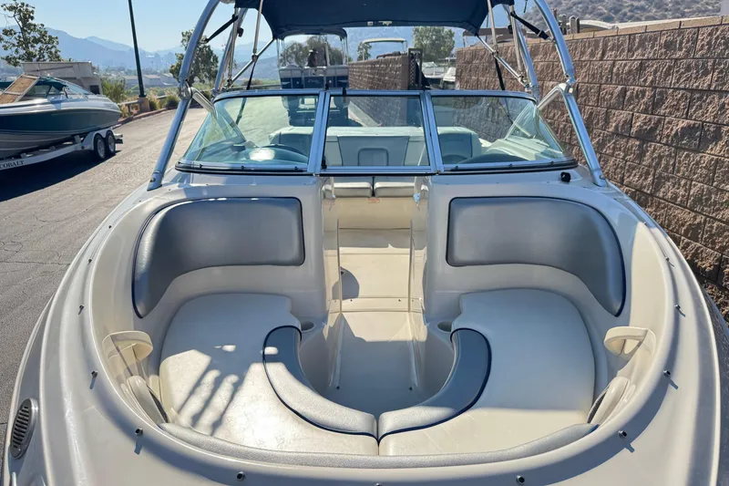 Slide: The Image of 2008 Sea Ray 205 Sport boat interior with seating and windshield, parked outdoors. - 11