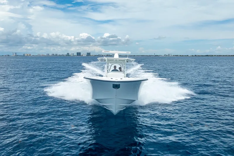 Slide: The Image of 2016 Yellowfin 39 Offshore boat cruising on open ocean with city skyline in background. - 11