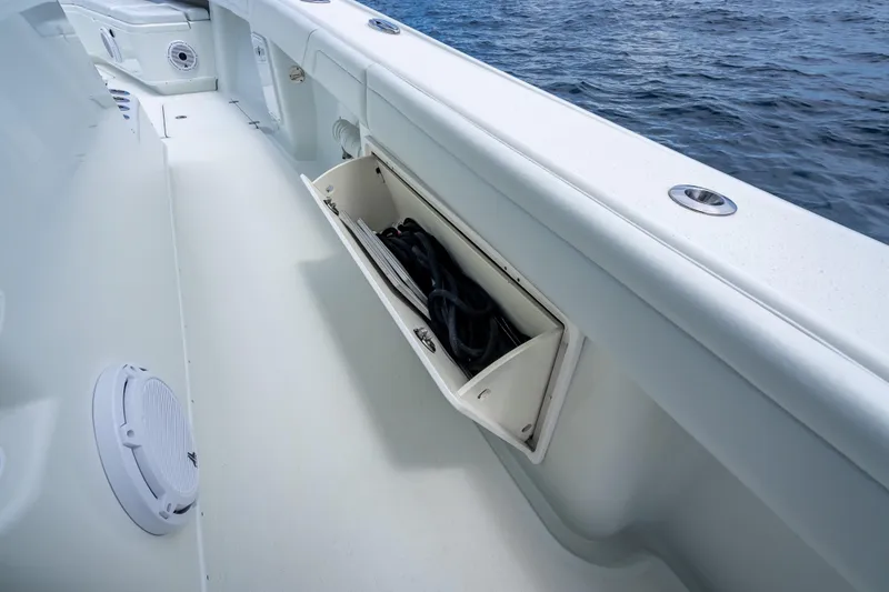 Slide: The Image of 2016 Yellowfin 39 Offshore boat deck with open storage compartment by the ocean. - 55