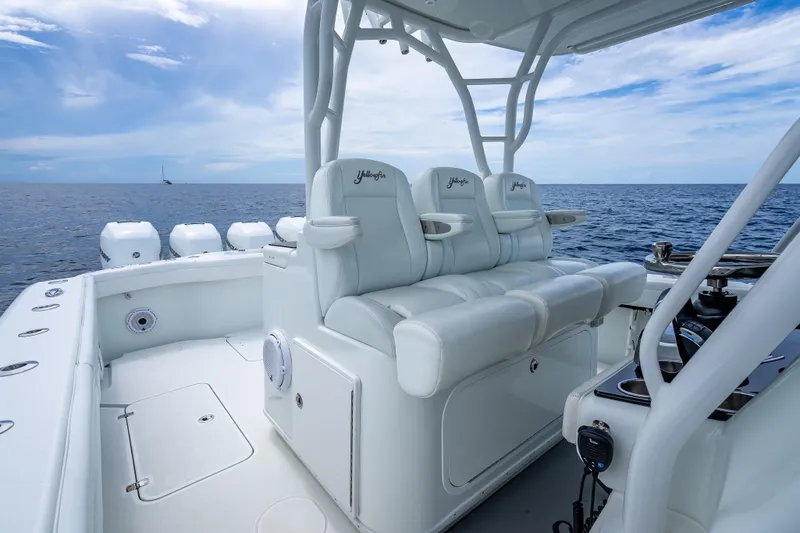Slide: The Image of 2016 Yellowfin 39 Offshore boat interior with white seating, ocean view, and clear sky. - 31