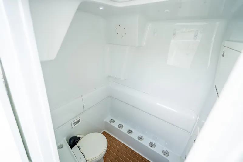 Slide: The Image of 2016 Yellowfin 39 Offshore boat interior with white marine toilet and seating. - 63
