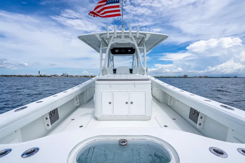Slide: The Image of 2016 Yellowfin 39 Offshore boat on open water, American flag waving, clear sky. - 36