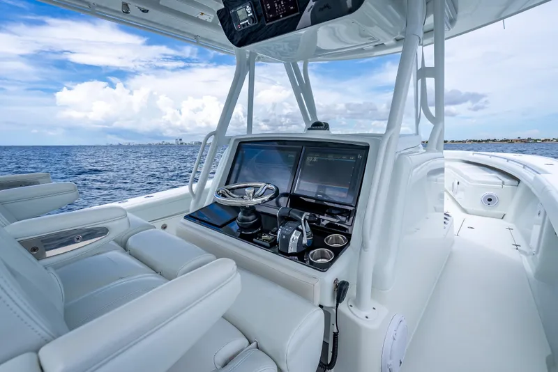 Slide: The Image of 2016 Yellowfin 39 Offshore boat cockpit with modern navigation system, steering wheel, and ocean view. - 23