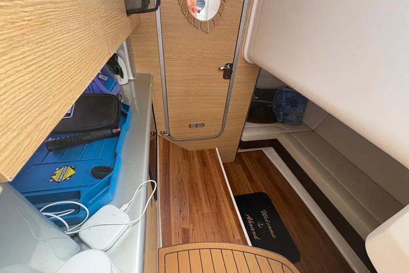 Slide: The Image of 2013 Chaparral 327 SSX cabin interior with wood flooring and storage compartments. - 16