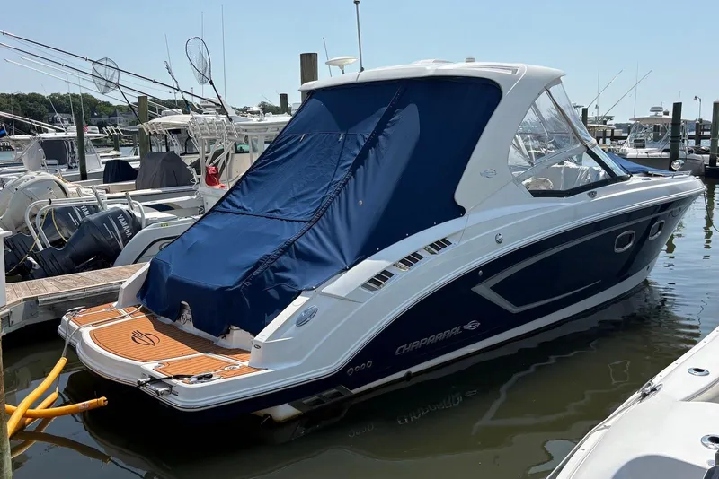 Slide: The Image of 2013 Chaparral 327 SSX boat docked at marina with blue cover. - 5