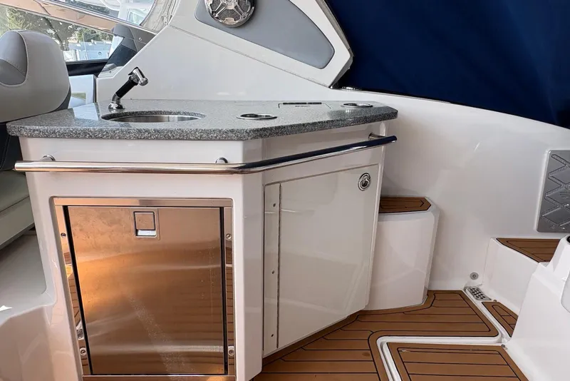 Slide: The Image of 2013 Chaparral 327 SSX boat interior with kitchenette and stainless steel features. - 12