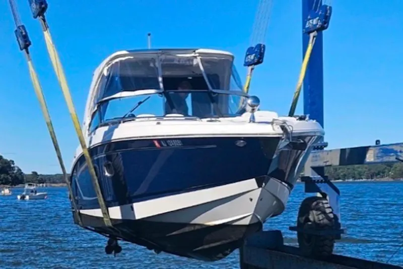 Slide: The Image of 2013 Chaparral 327 SSX boat being lifted from water by crane. - 3