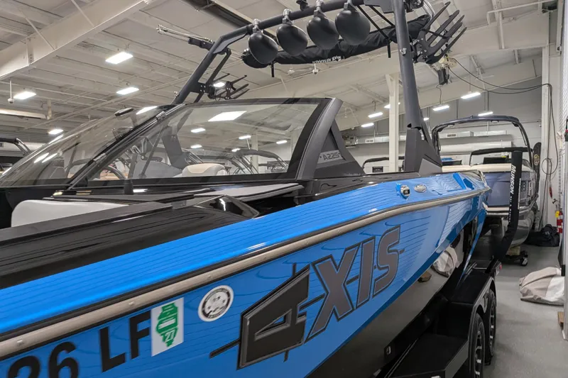 Slide: The Image of 2023 Axis A225 boat in showroom, featuring sleek blue design and modern equipment. - 17