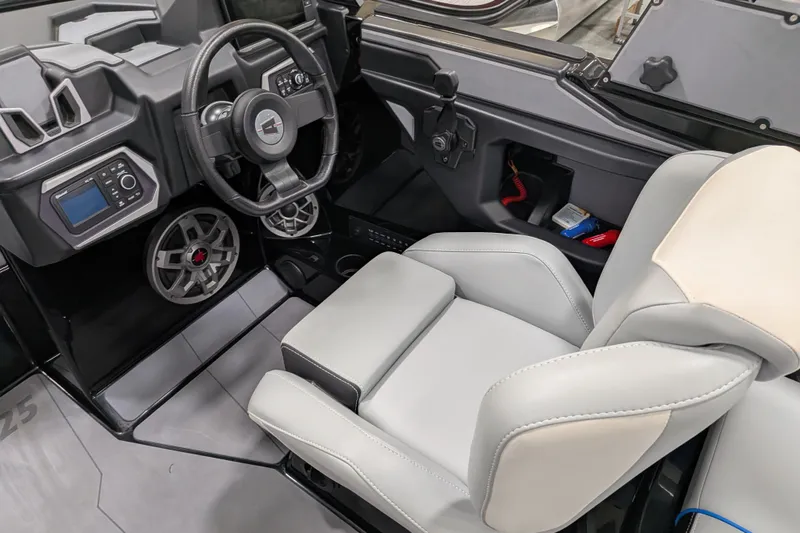 Slide: The Image of 2023 Axis A225 boat interior with steering wheel, dashboard, and gray seating. - 33