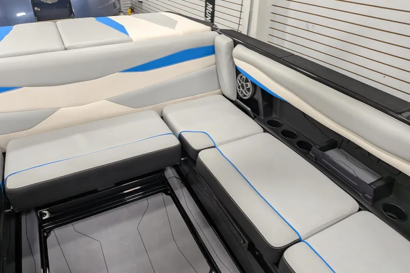 Slide: The Image of 2023 Axis A225 boat interior with gray and blue seating, cup holders, and speaker. - 30