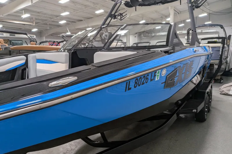 Slide: The Image of 2023 Axis A225 boat in showroom, featuring sleek blue design and modern interior. - 18