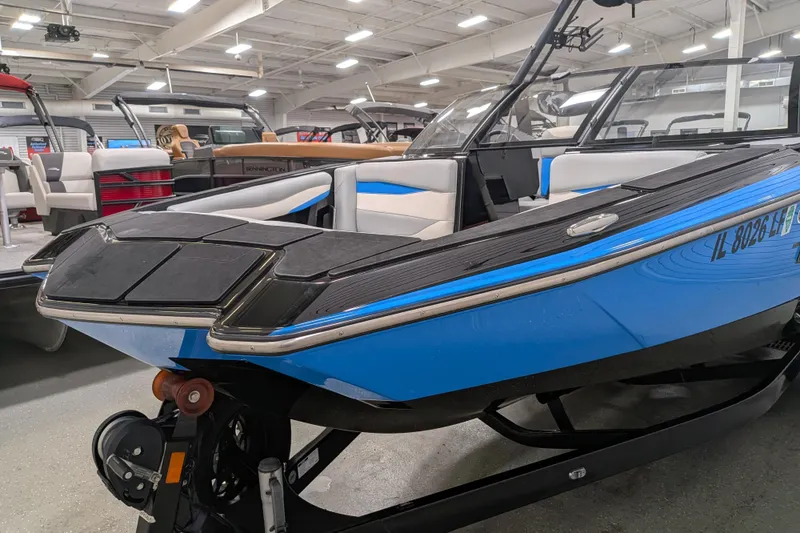 Slide: The Image of 2023 Axis A225 boat in showroom, featuring sleek blue design and modern interior. - 16