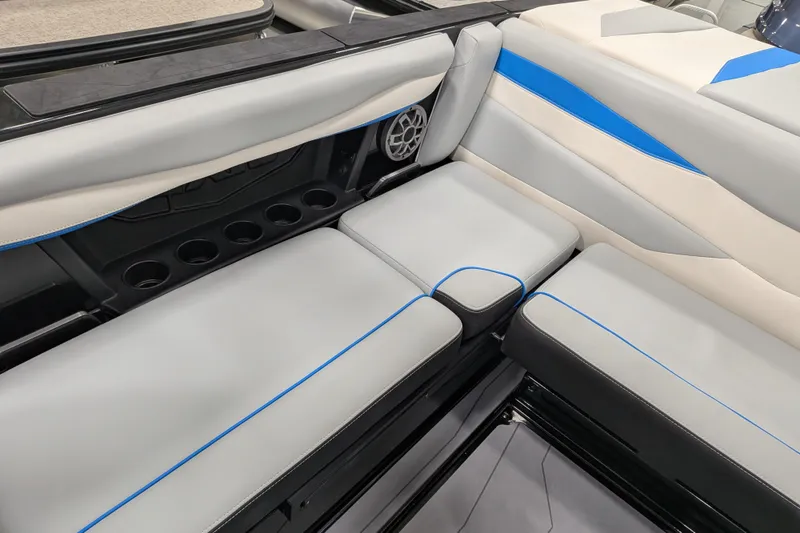 Slide: The Image of 2023 Axis A225 boat interior with gray and blue seating, cup holders, and speaker. - 32