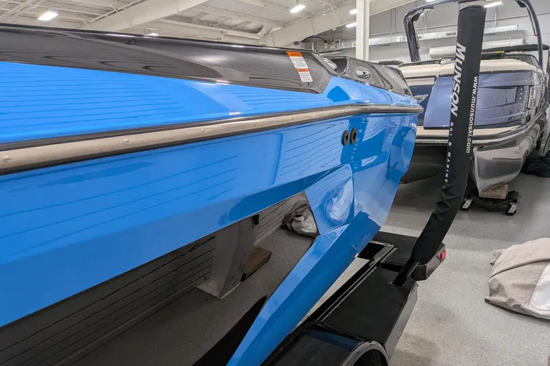 Slide: The Image of 2023 Axis A225 boat in showroom, featuring sleek blue design and modern detailing. - 21