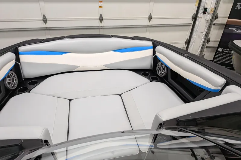 Slide: The Image of 2023 Axis A225 boat interior with gray and blue seating, cup holders, and speakers. - 27