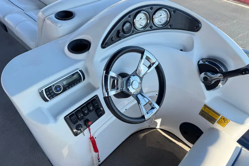 Slide: The Image of Steering console of 2014 Bentley Pontoons Encore 240 Cruise with chrome accents and gauges. - 22