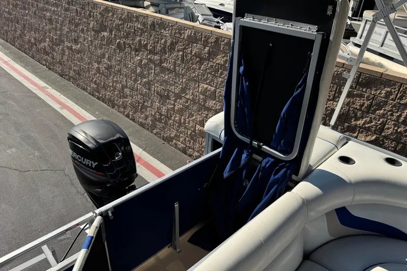 Slide: The Image of 2014 Bentley Pontoons Encore 240 Cruise with Mercury outboard motor, docked near a stone wall. - 17