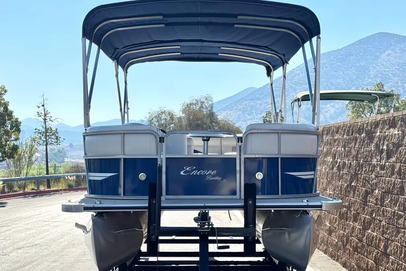 Slide: The Image of 2014 Bentley Pontoons Encore 240 Cruise on trailer, scenic mountain backdrop. - 2