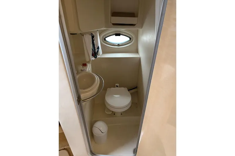 Slide: The Image of Compact bathroom in 2001 Maxum 2900 SCR boat with sink, toilet, and porthole window. - 8