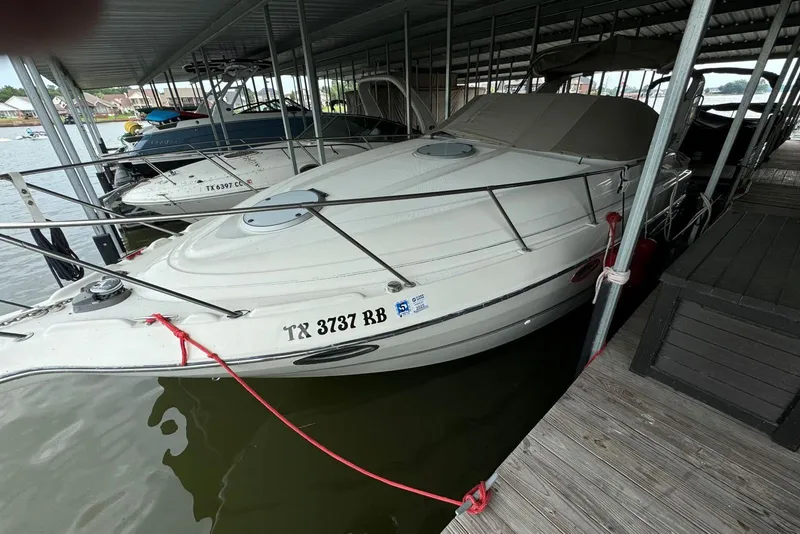 The Image of 2001 Maxum 2900 SCR boat docked in a marina, featuring sleek design and white exterior. - 0