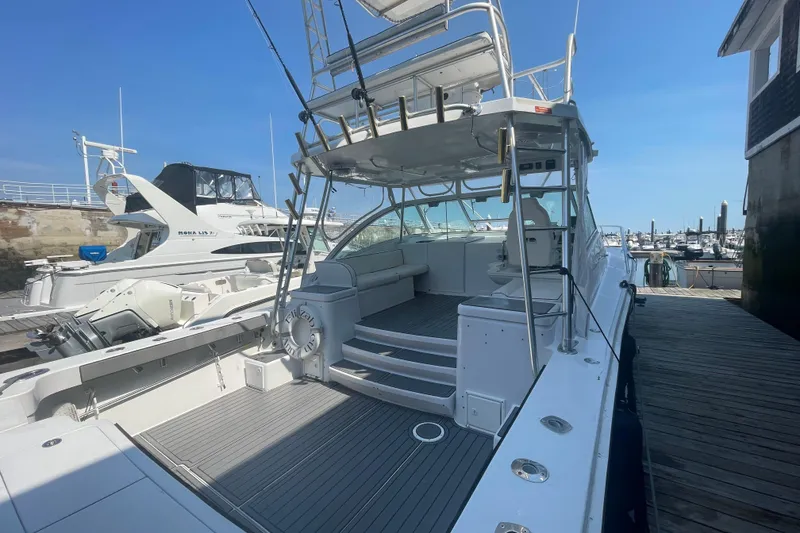 Slide: The Image of 1999 Luhrs 36 SX Open yacht docked at marina, showcasing spacious deck and seating area. - 12