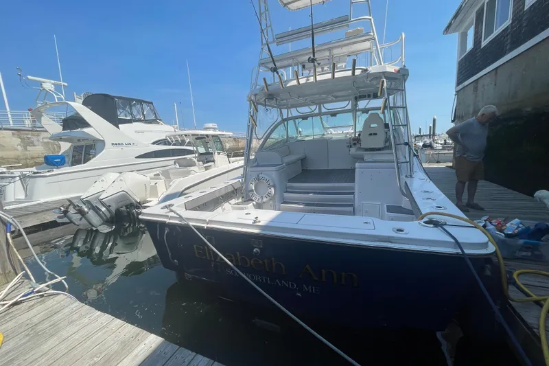 Slide: The Image of 1999 Luhrs 36 SX Open boat docked, named "Elizabeth Ann," with a person nearby. - 4