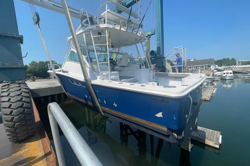 Slide: The Image of 1999 Luhrs 36 SX Open boat being lifted at a marina dock. - 47