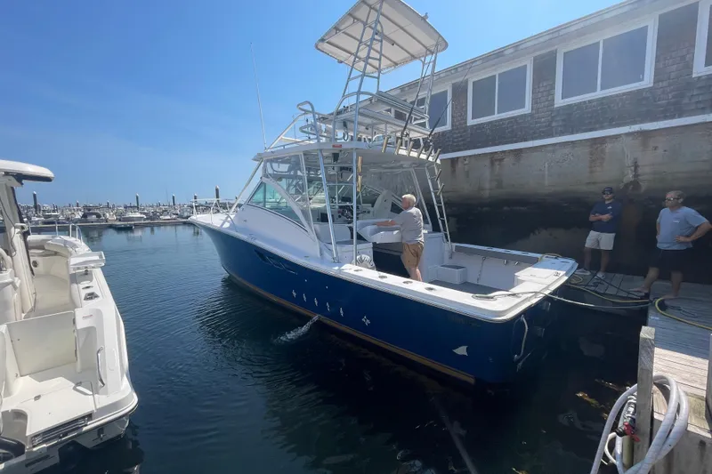 The Image of 1999 Luhrs 36 SX Open boat docked at marina, featuring blue hull and tower. - 1