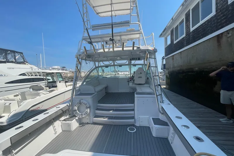 Slide: The Image of 1999 Luhrs 36 SX Open boat docked, featuring spacious deck and seating area. - 15