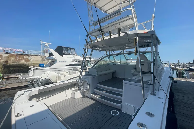 Slide: The Image of 1999 Luhrs 36 SX Open yacht docked, showcasing spacious deck and seating area. - 9