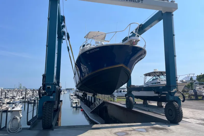 Slide: The Image of 1999 Luhrs 36 SX Open boat being lifted at a marina. - 42