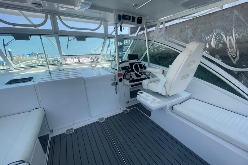 Slide: The Image of 1999 Luhrs 36 SX Open boat cockpit with helm, seating, and panoramic windows. - 18