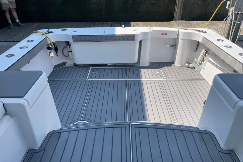 Slide: The Image of 1999 Luhrs 36 SX Open boat deck with gray flooring and fishing rod holders. - 27
