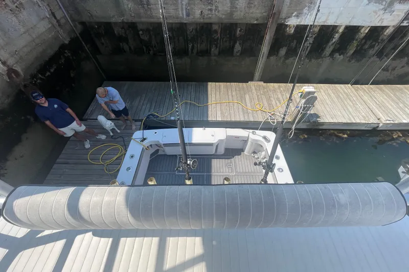 Slide: The Image of 1999 Luhrs 36 SX Open boat docked, viewed from above, with two people and a dog nearby. - 41
