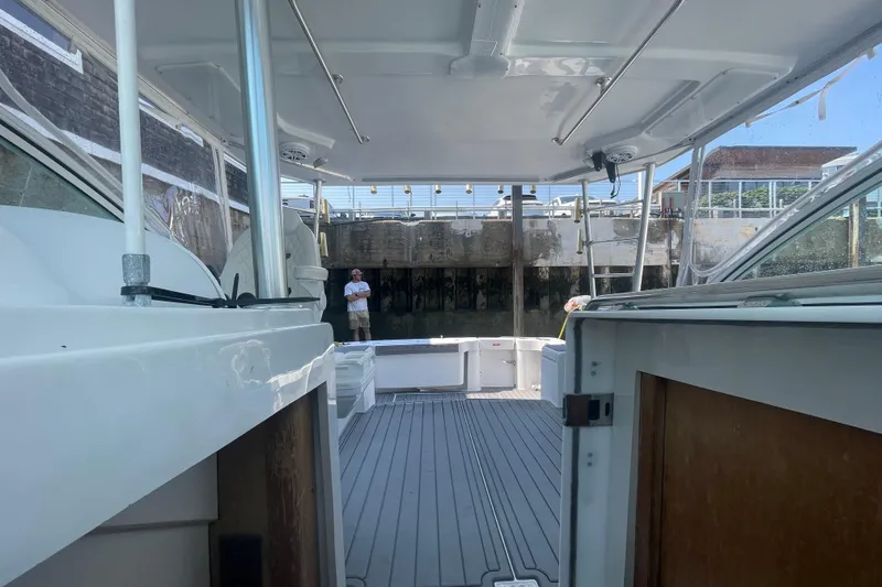 Slide: The Image of 1999 Luhrs 36 SX Open boat interior with dock view, featuring spacious deck and seating. - 33