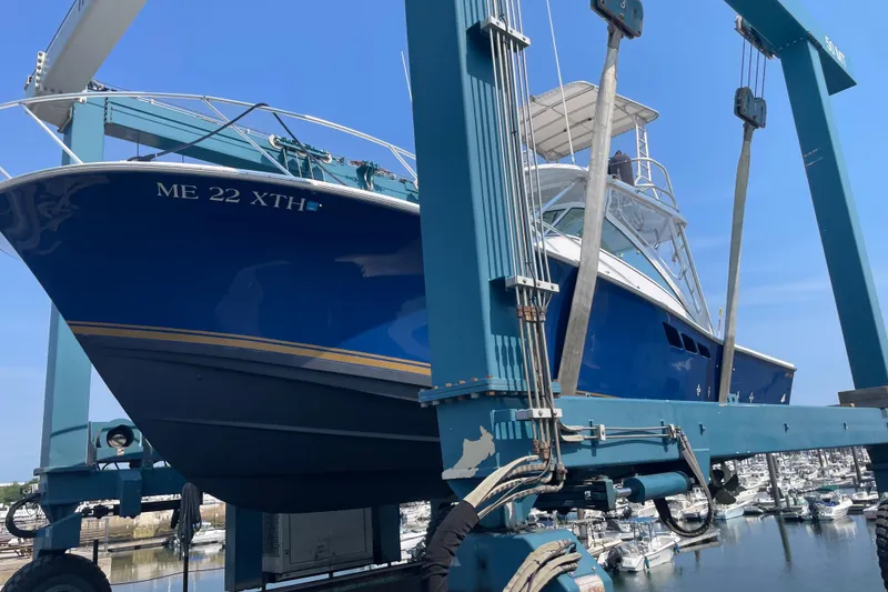 Slide: The Image of 1999 Luhrs 36 SX Open boat in dry dock, blue hull, marina background. - 44