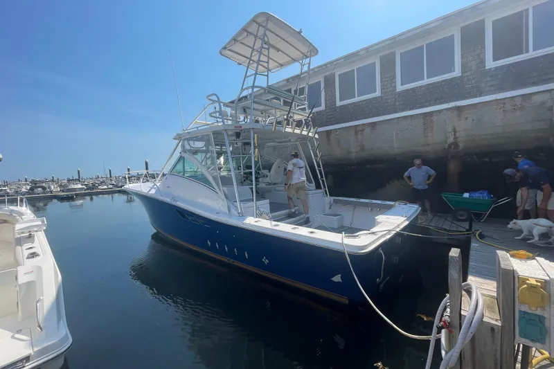 Slide: The Image of 1999 Luhrs 36 SX Open boat docked at marina with people nearby. - 2