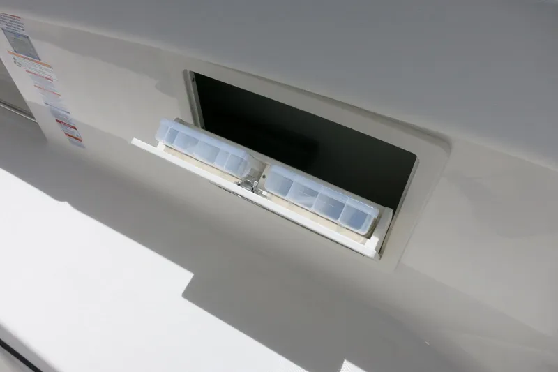 Slide: The Image of 2026 Robalo R270 Center Console storage compartment with tackle boxes. - 29