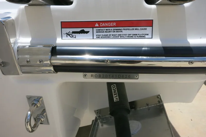 Slide: The Image of 2026 Robalo R270 Center Console boat stern with safety warning label and serial number. - 2