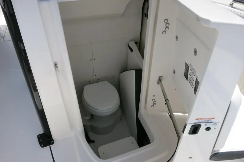 Slide: The Image of 2026 Robalo R270 Center Console boat interior with compact marine toilet. - 28