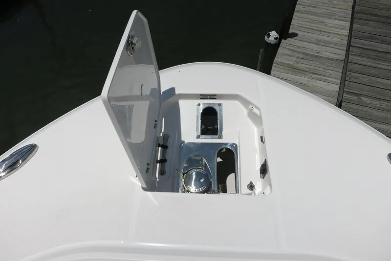 Slide: The Image of 2026 Robalo R270 Center Console boat anchor compartment, open hatch, dockside view. - 27