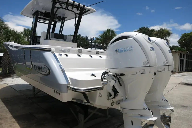 Slide: The Image of 2026 Robalo R270 Center Console boat with dual Yamaha engines, docked outdoors. - 41