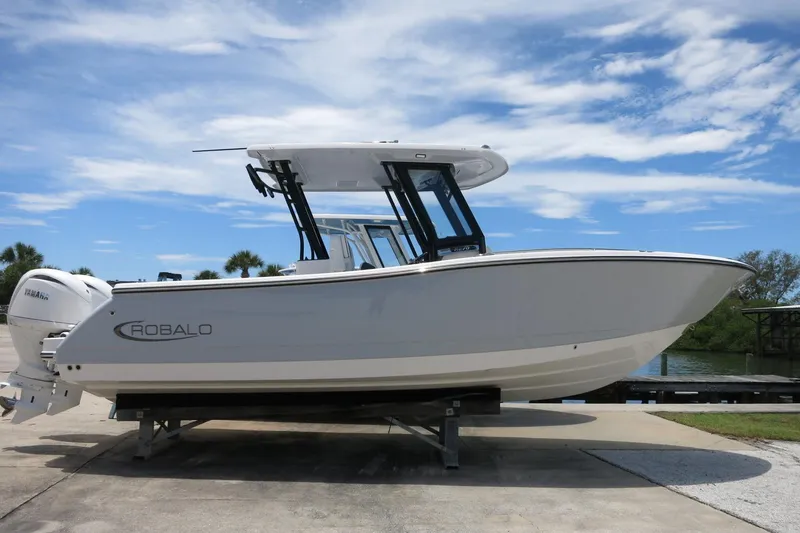The Image of 2026 Robalo R270 Center Console boat on display under a clear blue sky. - 0