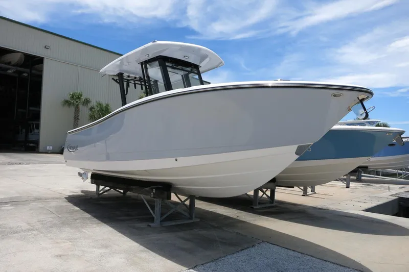 Slide: The Image of 2026 Robalo R270 Center Console boat displayed outdoors on a sunny day. - 38