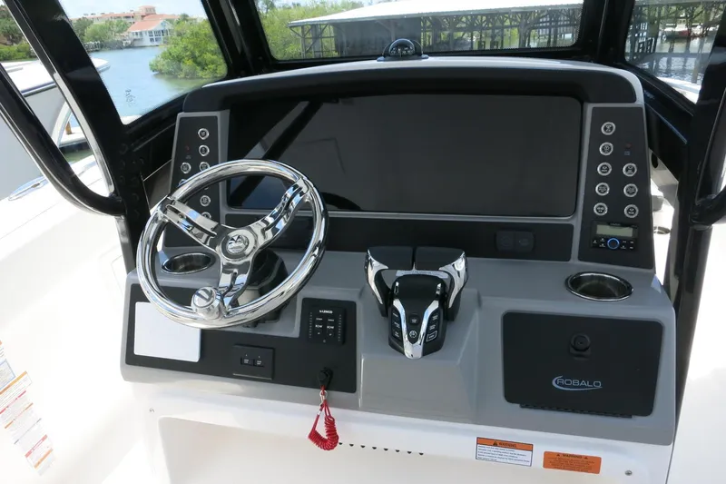 Slide: The Image of 2026 Robalo R270 Center Console boat dashboard with steering wheel and controls. - 20