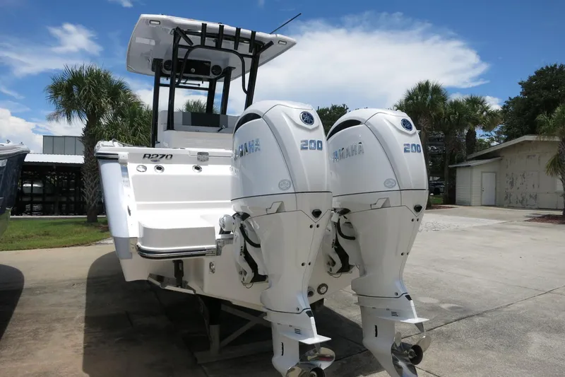 Slide: The Image of 2026 Robalo R270 Center Console boat with dual Yamaha 200 engines, parked outdoors. - 40